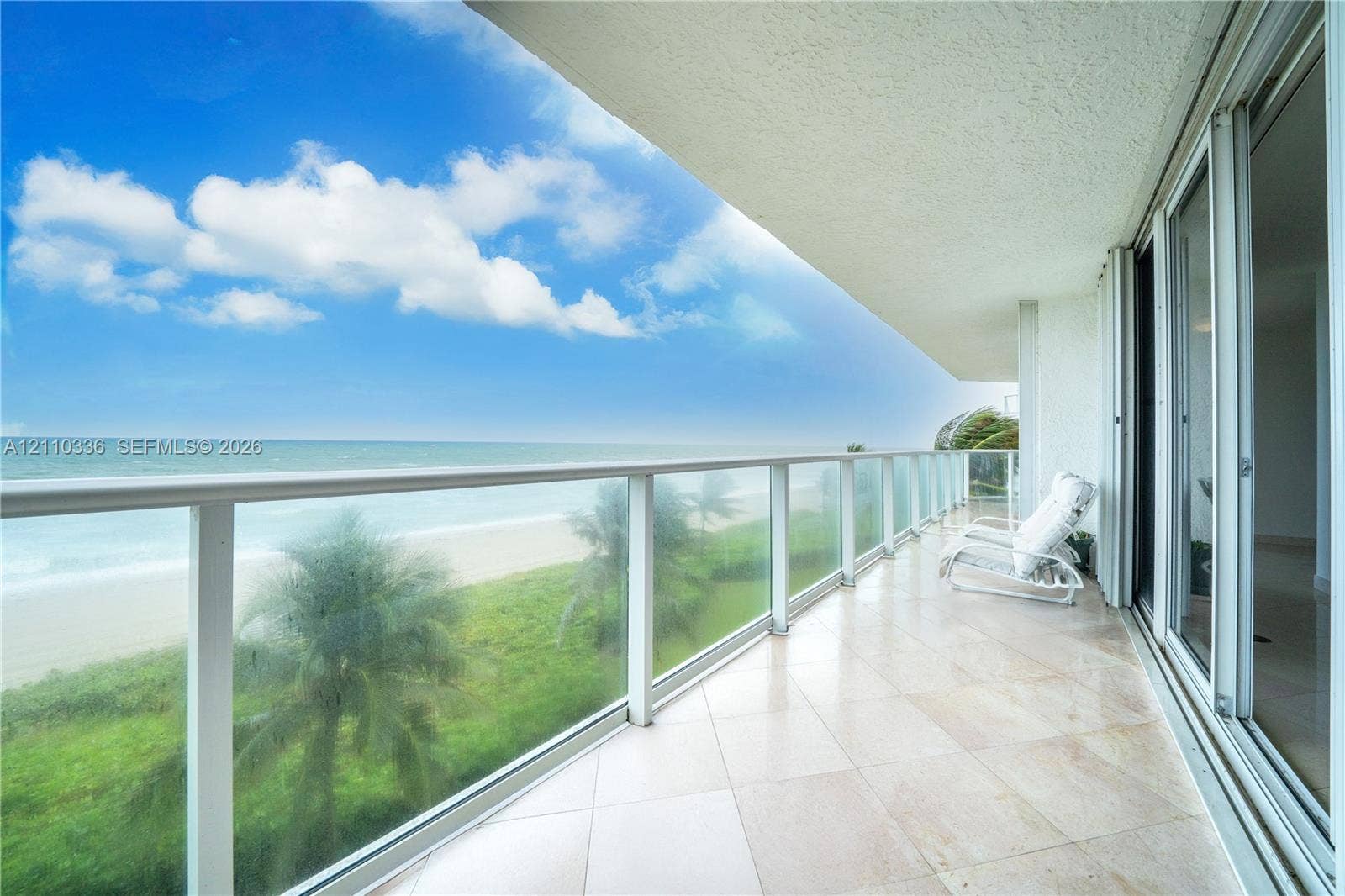 16445 Collins Avenue, #WS-7B, Sunny Isles Beach, Sunny Isles Beach, FL 33160 Covered balcony featuring stone tile flooring and a glass railing, encompassing water scenery