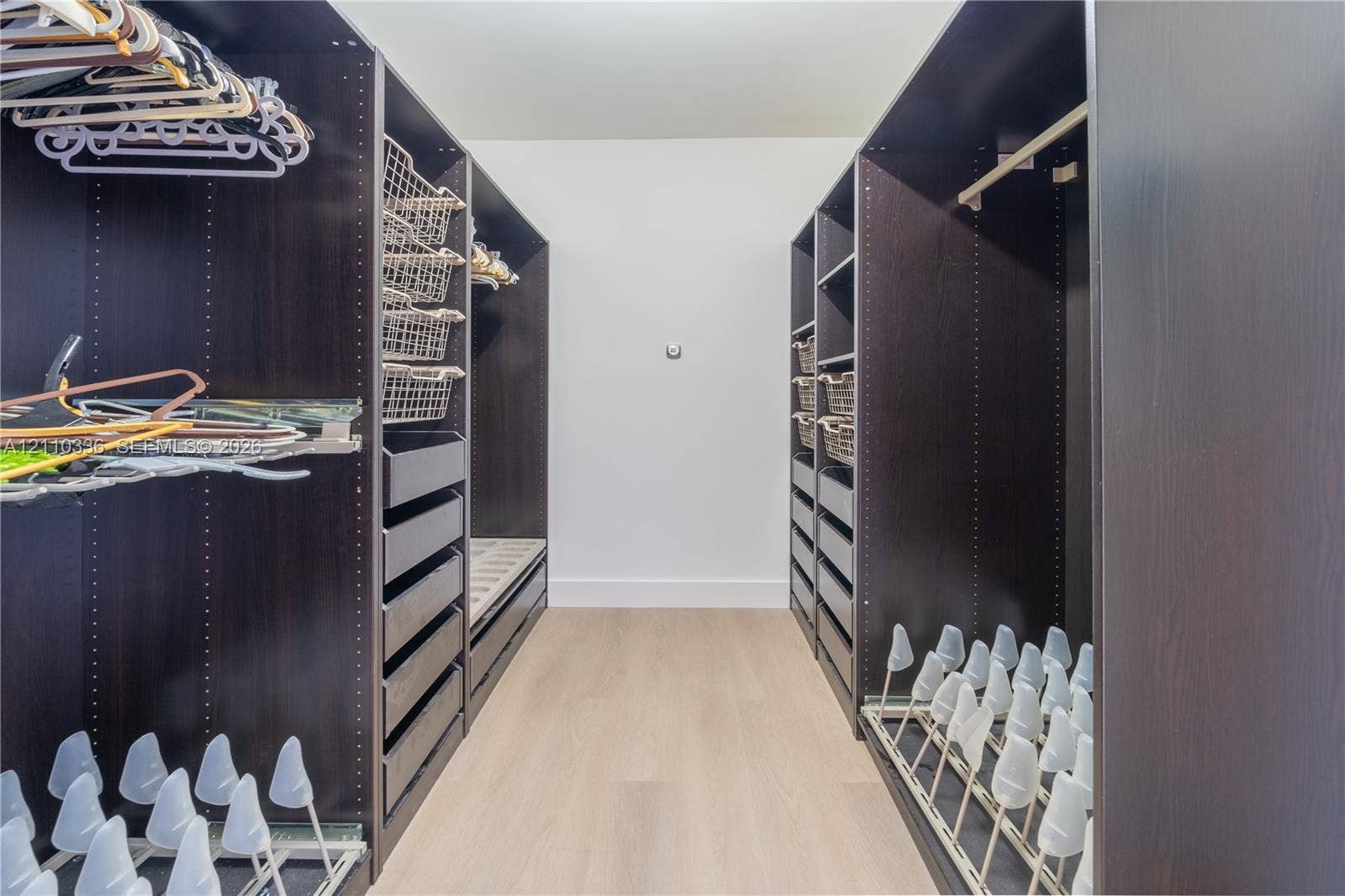 16445 Collins Avenue, #WS-7B, Sunny Isles Beach, Sunny Isles Beach, FL 33160 Custom closet featuring dark wood-finish cabinetry, built-in drawer units, integrated wire shelving, and slide-out shoe storage racks