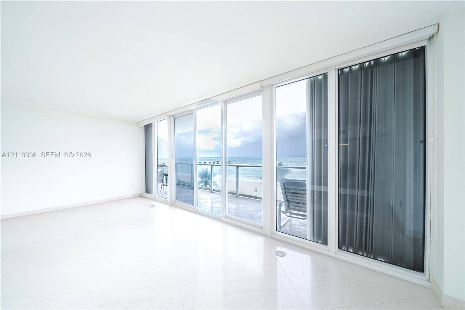 16445 Collins Avenue, #WS-7B, Sunny Isles Beach, Sunny Isles Beach, FL 33160 Floor-to-ceiling glass sliding doors, polished tile flooring, and a private balcony featuring a metal railing