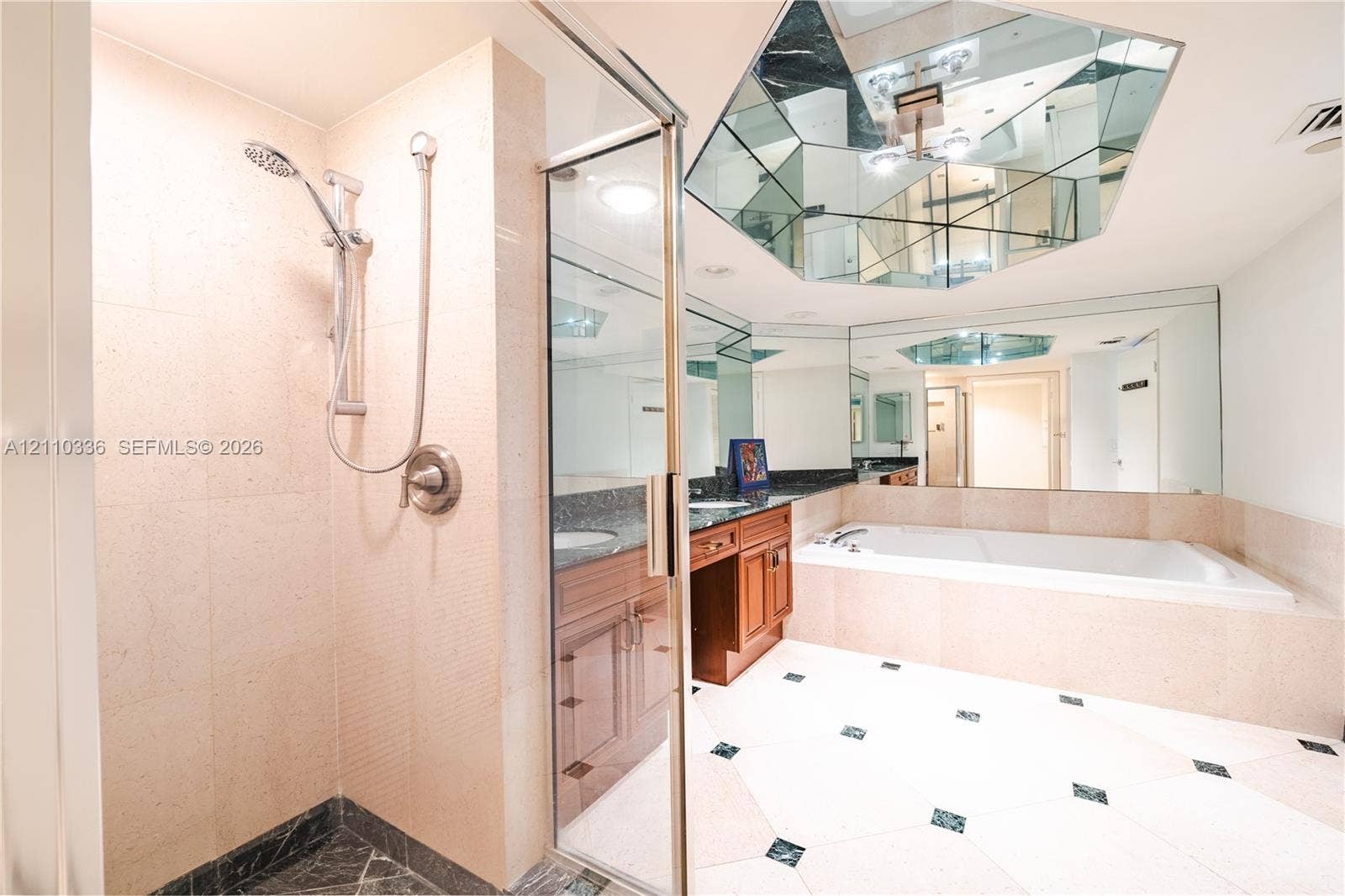 16445 Collins Avenue, #WS-7B, Sunny Isles Beach, Sunny Isles Beach, FL 33160 Enclosed shower with handheld fixture, built-in soaking tub, wood-finish cabinetry, stone countertop, and geometric mirrored ceiling accent