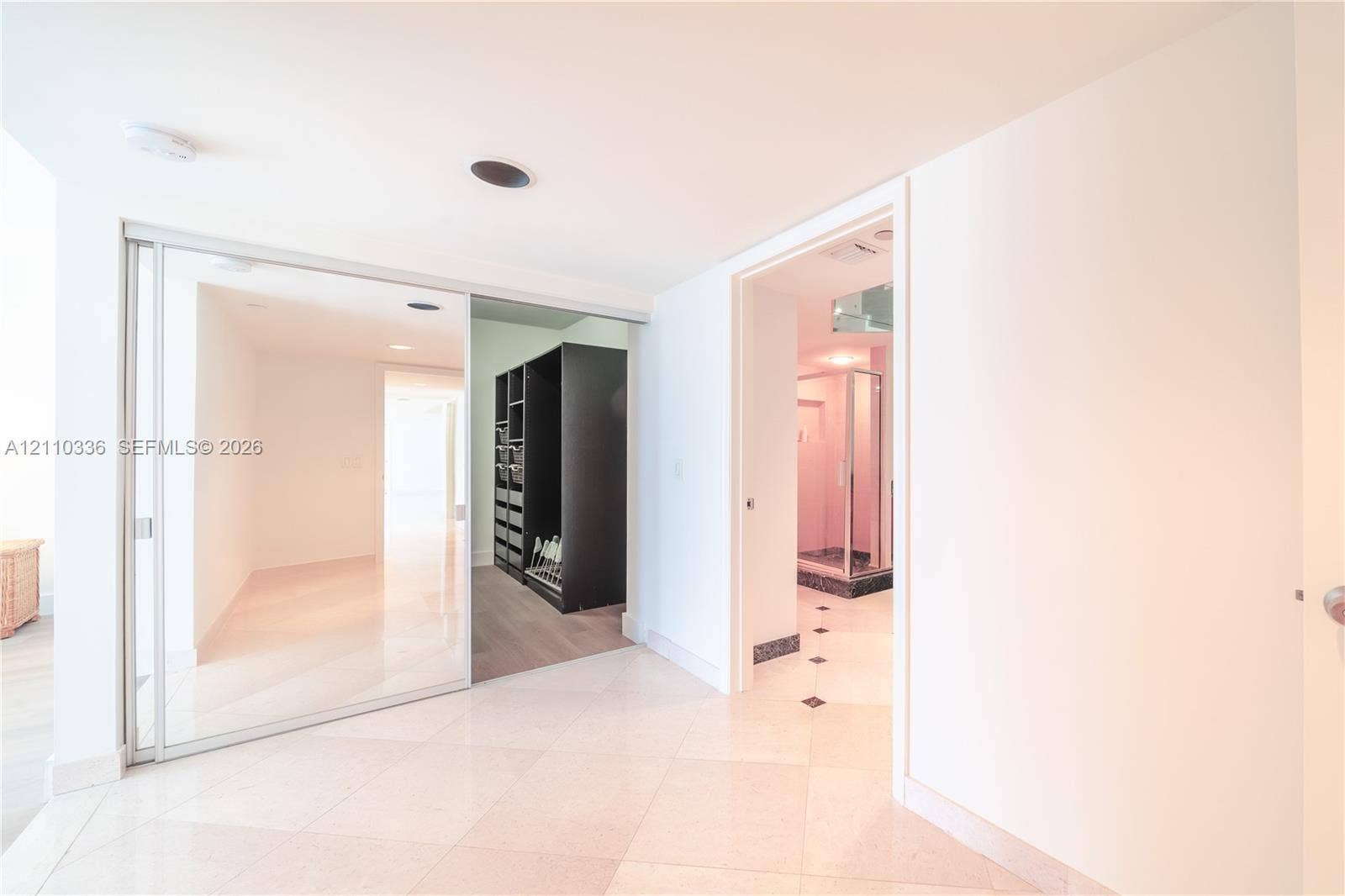 16445 Collins Avenue, #WS-7B, Sunny Isles Beach, Sunny Isles Beach, FL 33160 Sliding glass-paneled closet doors, neutral stone-finish tile flooring, recessed ceiling lighting, and built-in closet shelving system