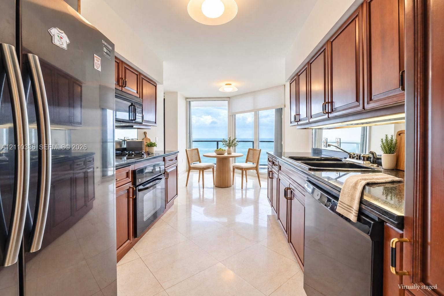 16445 Collins Avenue, #WS-7B, Sunny Isles Beach, Sunny Isles Beach, FL 33160 Galley kitchen featuring rich wood cabinetry, stone countertops, stainless steel appliances, and large-format tile flooring, complemented by expansive floor-to-ceiling windows