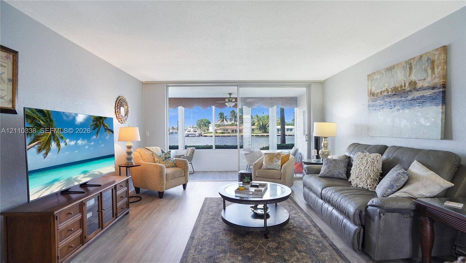 Living area featuring wood-finish flooring, sliding glass doors, and water scenery