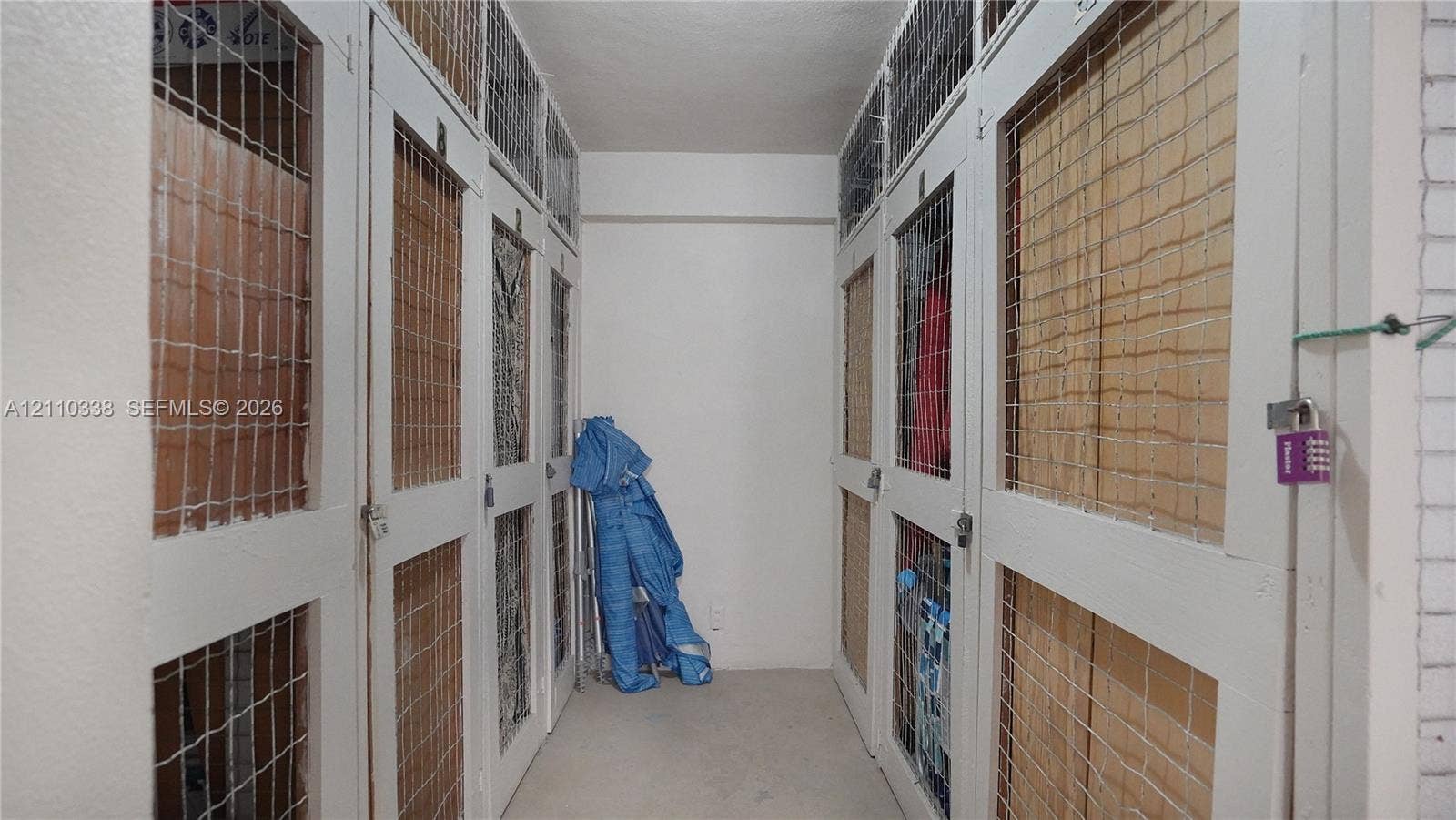 Dedicated storage area featuring individual lockers with white-painted wood frames, integrated wire-mesh panels, and secure locking hardware