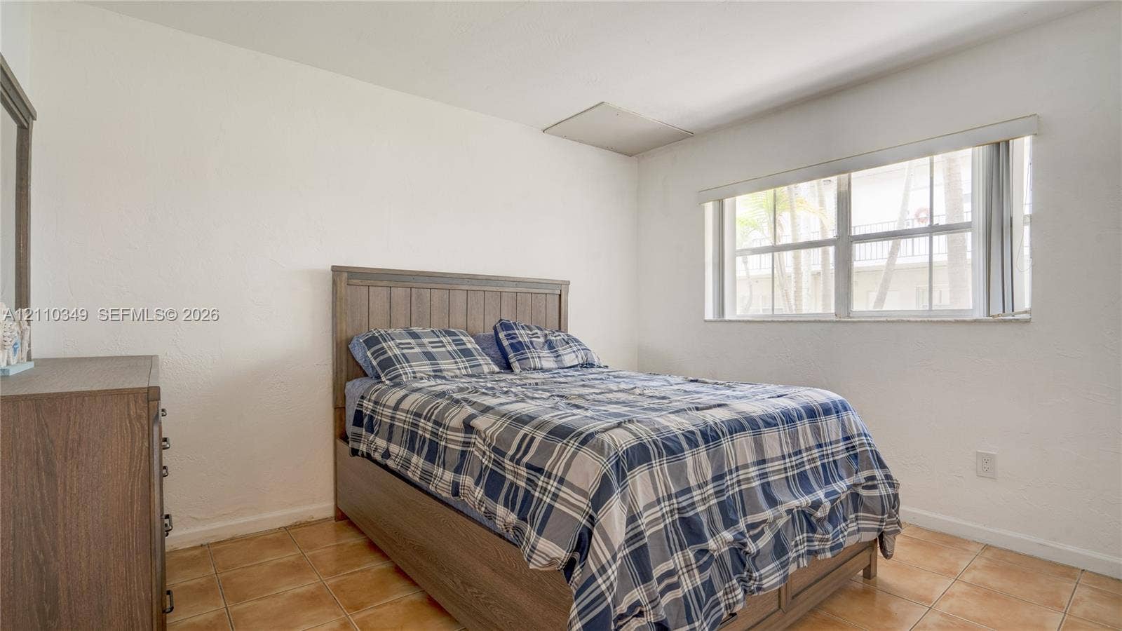 8600 SW 67th Avenue, #905, Pinecrest, Pinecrest, FL 33156 Neutral-toned bedroom featuring ceramic tile flooring, smooth wall finishes, and a window with horizontal blinds