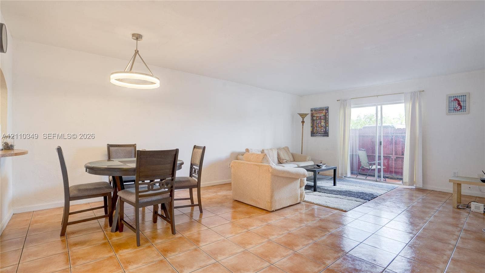 8600 SW 67th Avenue, #905, Pinecrest, Pinecrest, FL 33156 Ceramic tile flooring, minimalist circular pendant light fixture, and large glass sliding door providing outdoor access