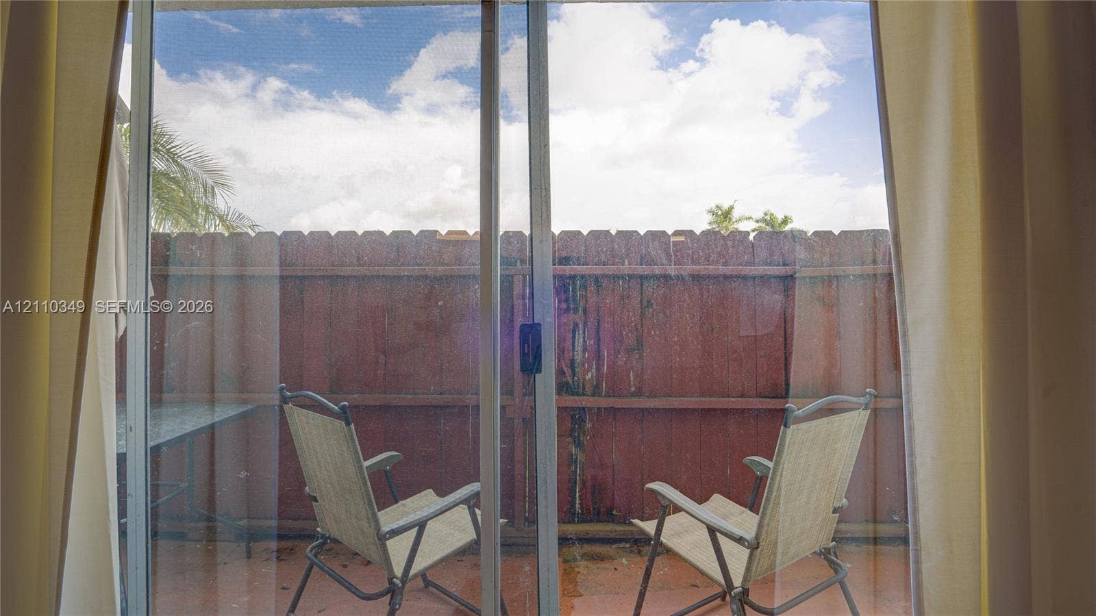 8600 SW 67th Avenue, #905, Pinecrest, Pinecrest, FL 33156 Sliding glass door opening to a paved patio area enclosed by a wood privacy fence