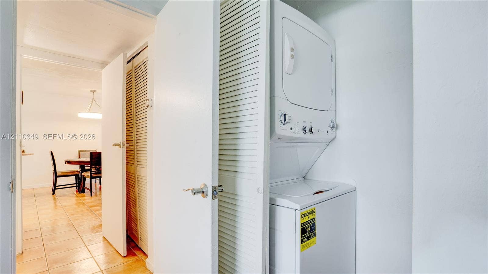 8600 SW 67th Avenue, #905, Pinecrest, Pinecrest, FL 33156 Stackable laundry unit housed within a closet featuring white louvered doors