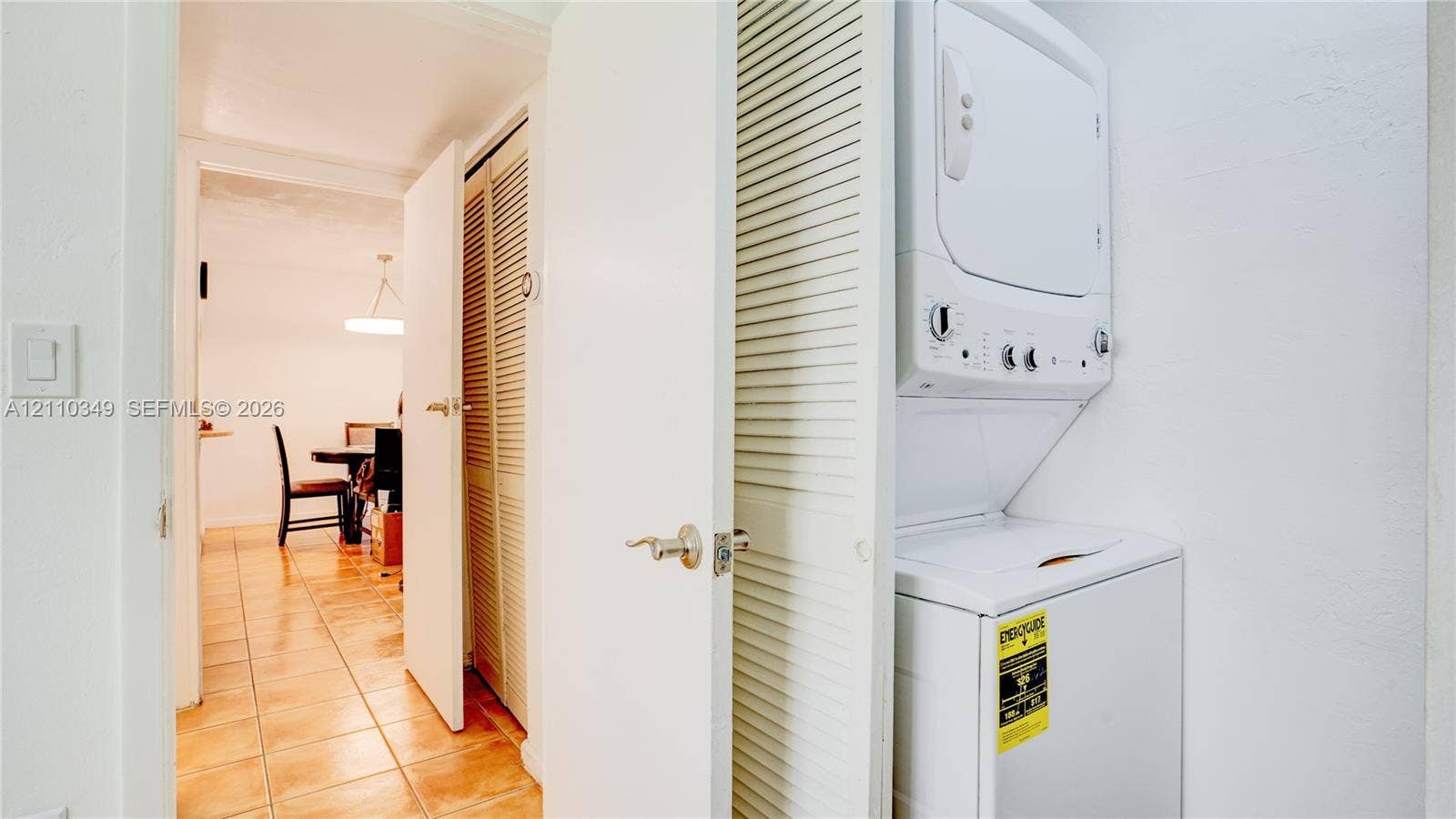 8600 SW 67th Avenue, #905, Pinecrest, Pinecrest, FL 33156 Laundry area featuring a stacked washer and dryer unit and floor-to-ceiling louvered closet doors