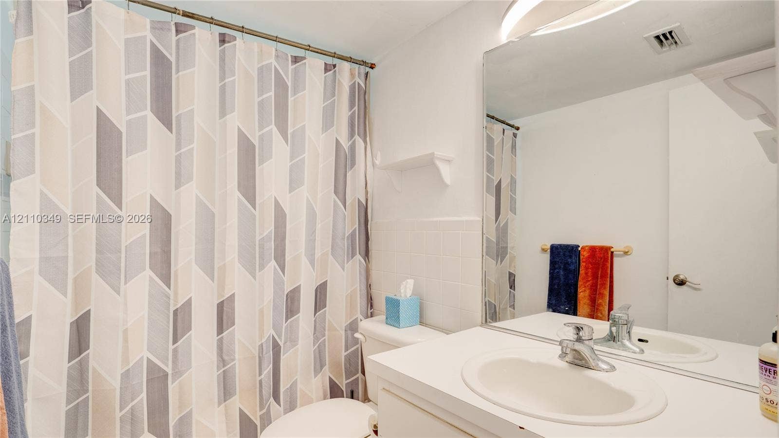8600 SW 67th Avenue, #905, Pinecrest, Pinecrest, FL 33156 Bathroom featuring a white vanity with an integrated sink, polished chrome faucet, wall-spanning mirror, and white tile tub surround