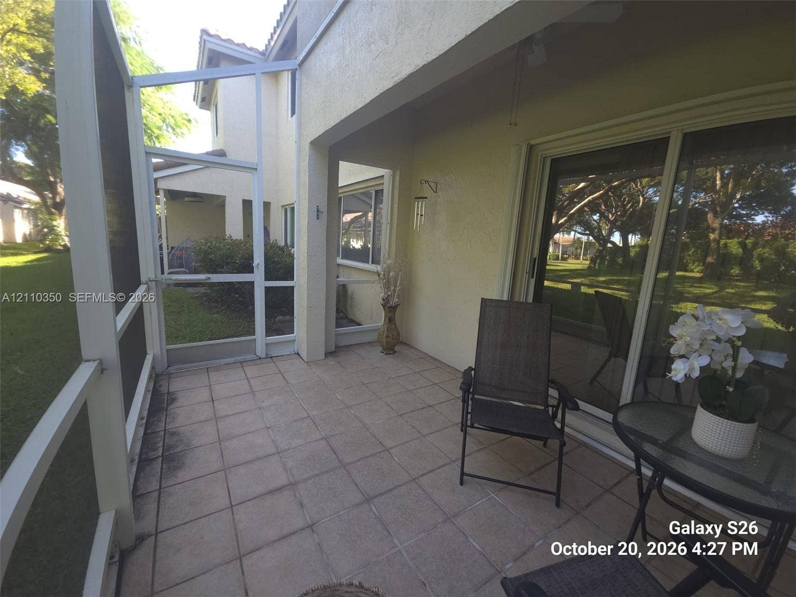 Screened lanai featuring tile flooring, a covered ceiling, and sliding glass entry doors