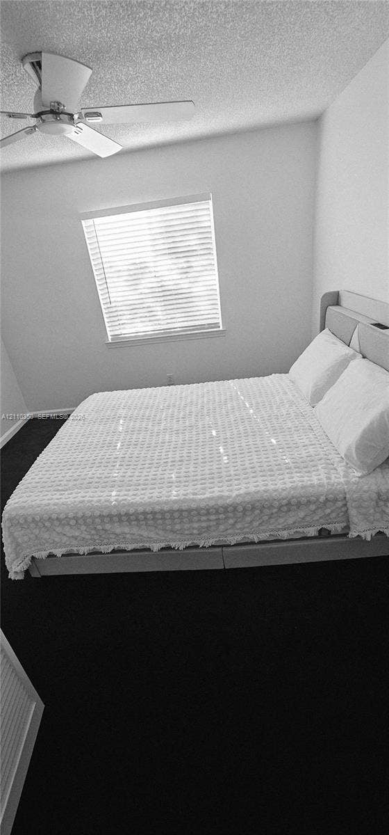 Room featuring neutral walls, ceiling fan, and window with horizontal blinds