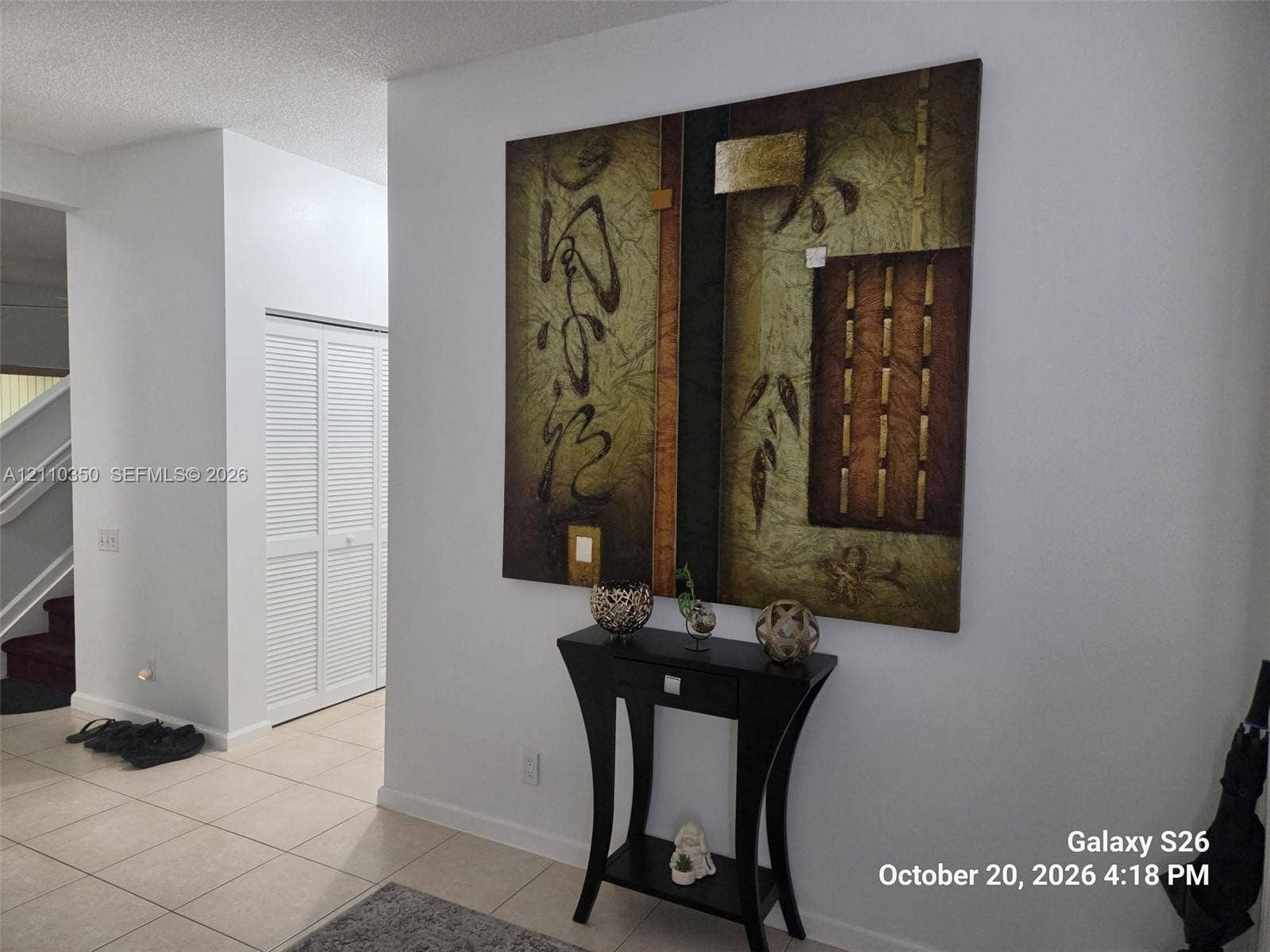 Neutral-toned tile flooring and double-panel louvered closet doors