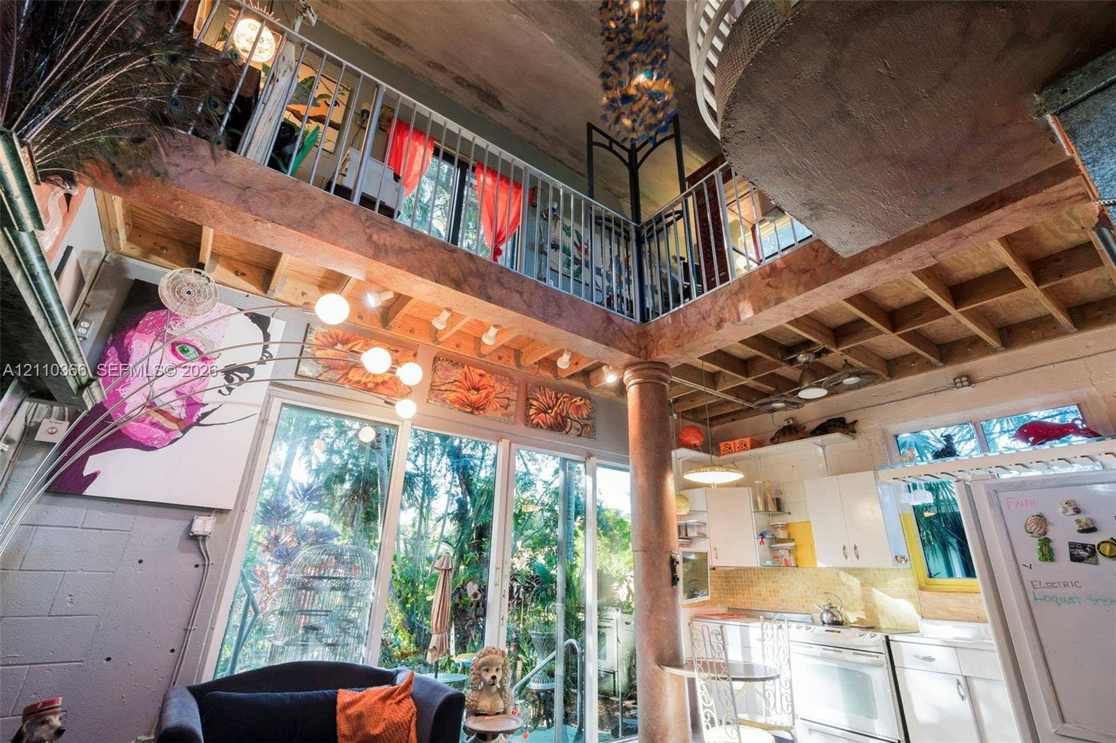2361 SW 18th Avenue, Fort Lauderdale, FL 33315 Exposed timber joist ceilings with double-height volume, central decorative column, interior metal-railed mezzanine, and floor-to-ceiling glass panel windows
