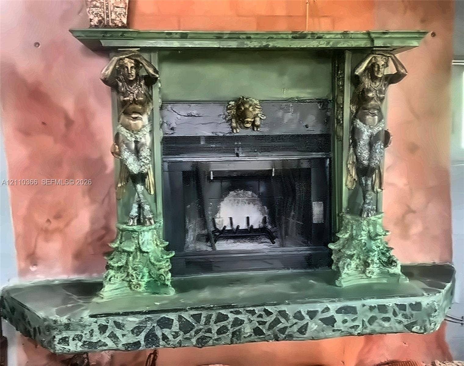 2361 SW 18th Avenue, Fort Lauderdale, FL 33315 Fireplace with a custom mantle featuring dual caryatid supports, a central lion-head relief, and an integrated stone-composite hearth