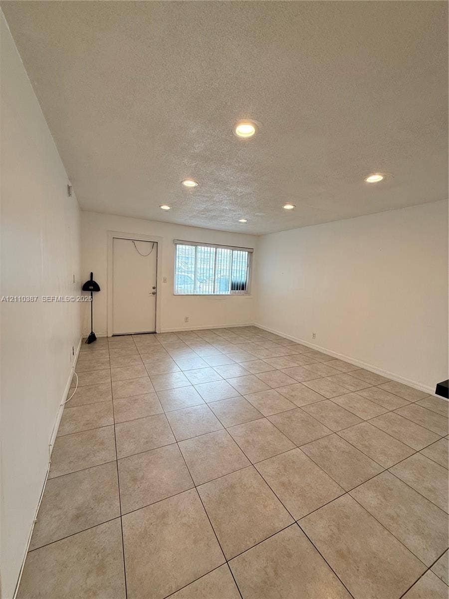 Neutral wall tones, ceramic tile flooring, and recessed ceiling lighting