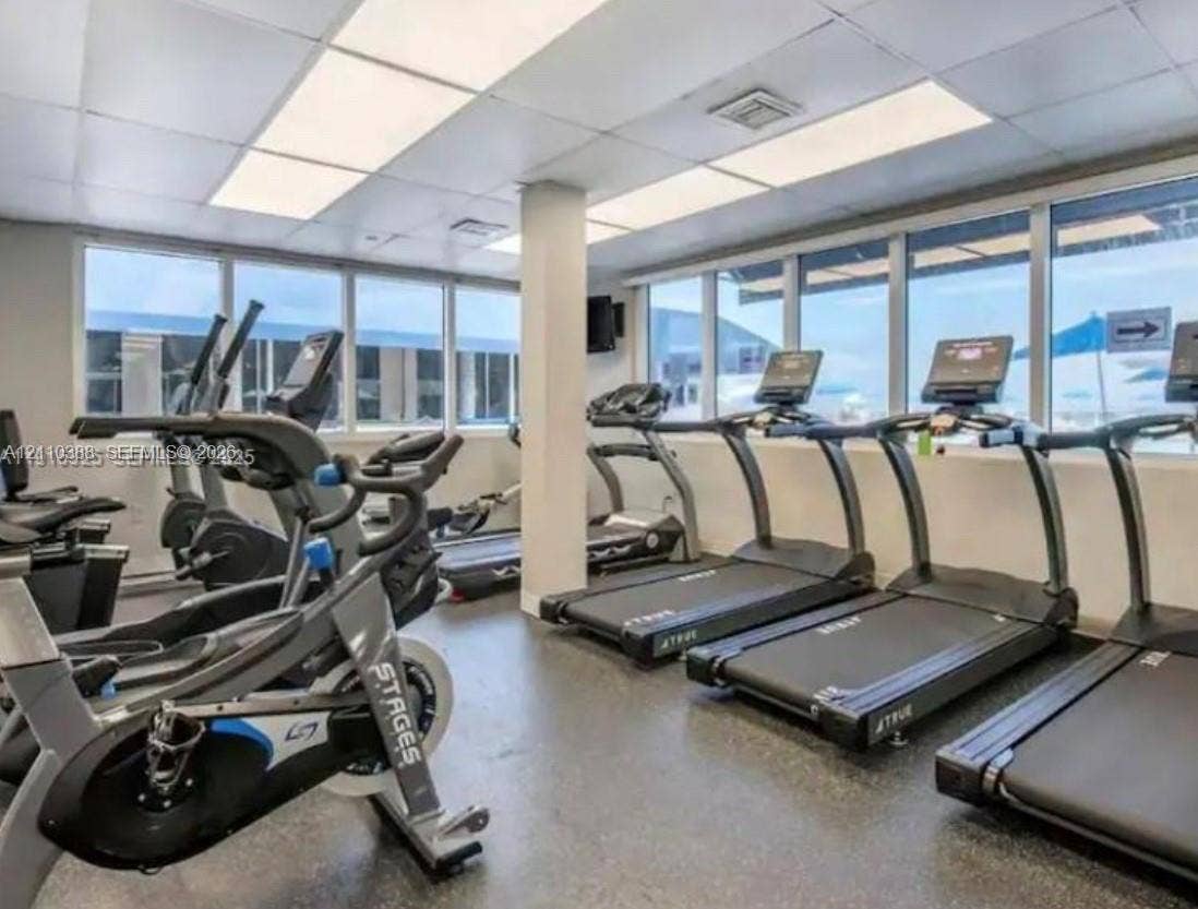 Fitness center featuring extensive floor-to-ceiling windows and recessed panel lighting