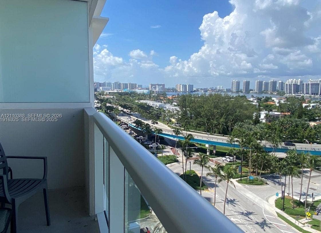 Private balcony featuring a glass-panel railing and concrete flooring