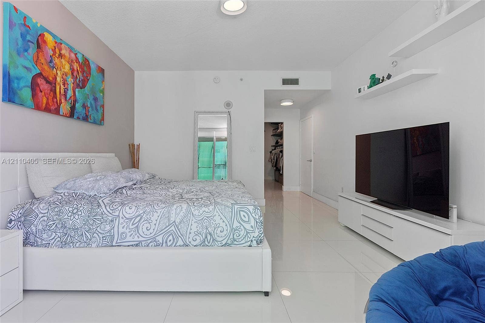Polished tile flooring, recessed ceiling lighting, and built-in wall shelving