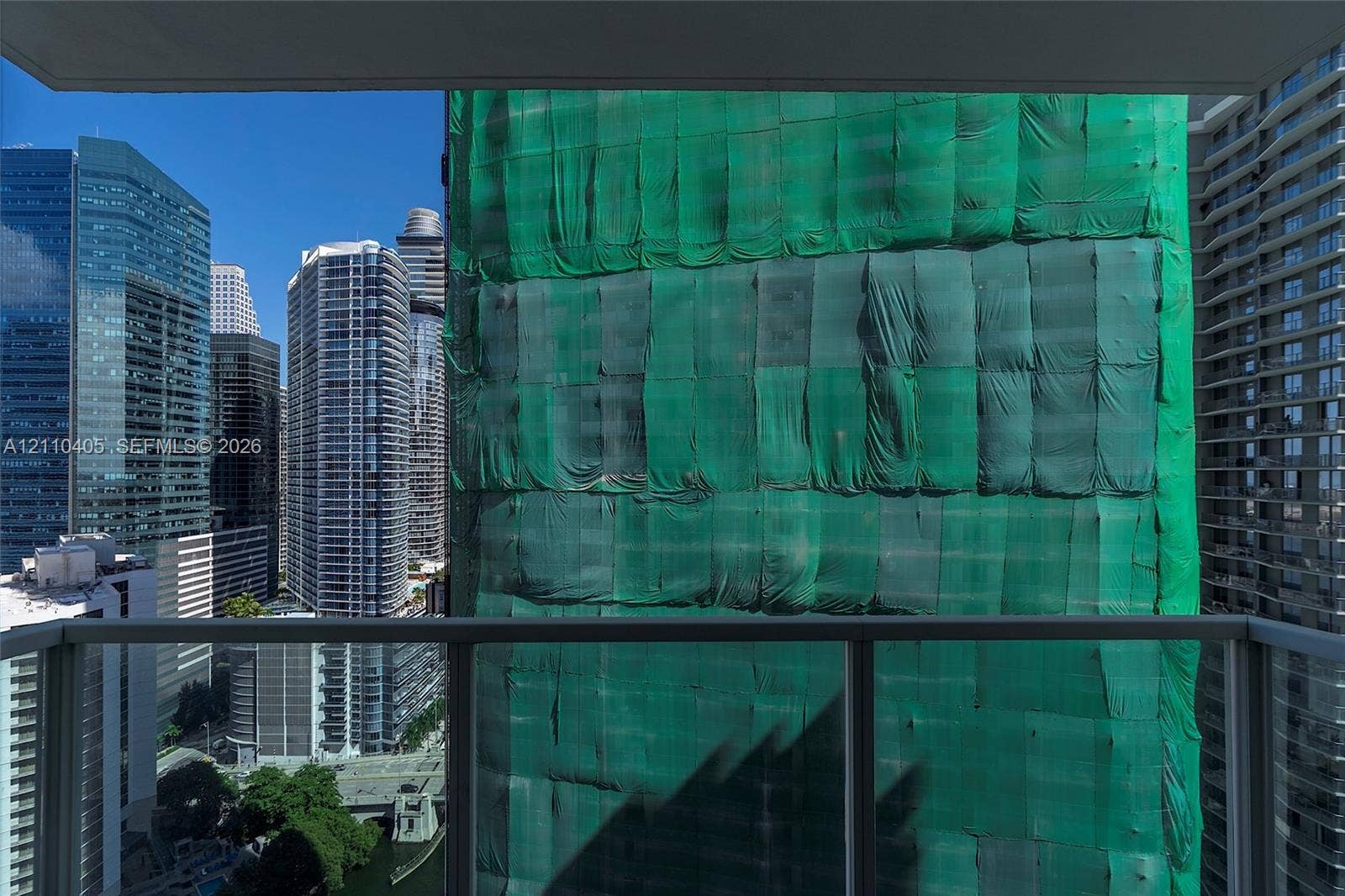 Outdoor balcony featuring a glass panel railing and urban skyline exposure