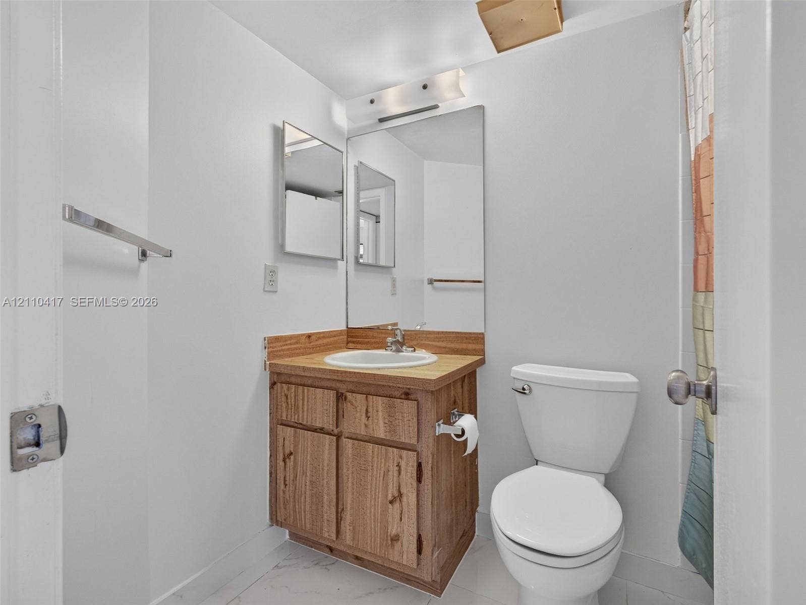 2369 NW 89th Drive, #514, Coral Springs, FL 33065 Bathroom featuring a wood-finish vanity with a drop-in sink, solid-surface countertop, full-width mirror, and three-light fixture
