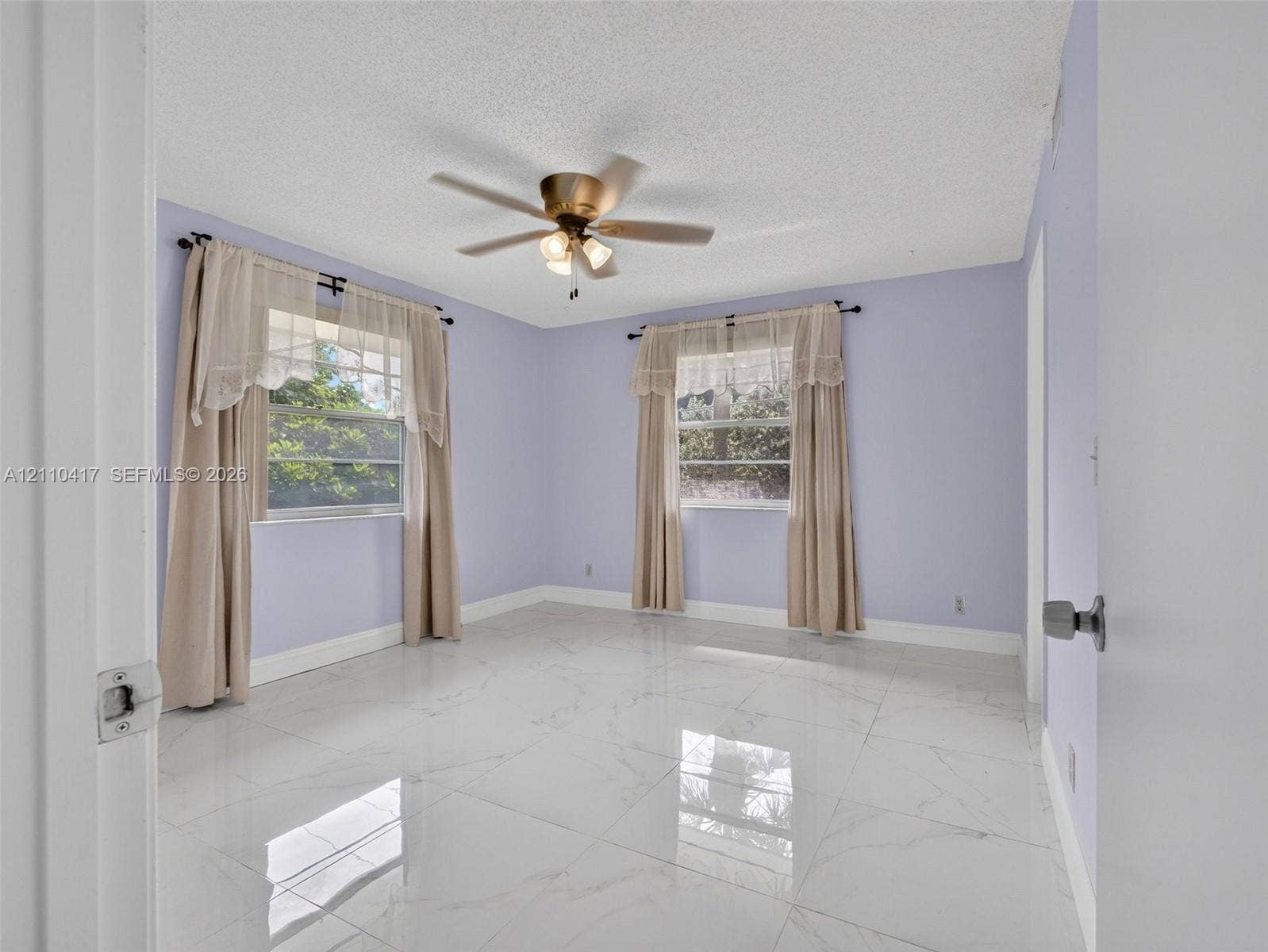 2369 NW 89th Drive, #514, Coral Springs, FL 33065 Large-format polished tile flooring, ceiling fan with integrated lighting, and multiple windows providing natural light