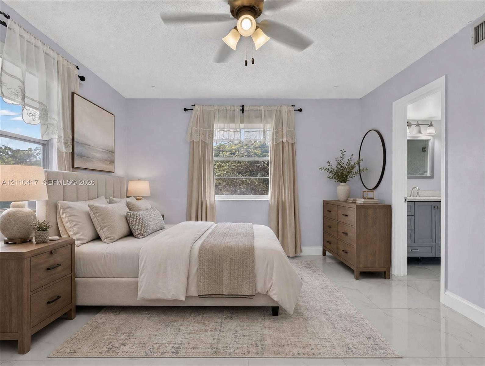 2369 NW 89th Drive, #514, Coral Springs, FL 33065 Neutral-toned bedroom featuring large-format tile flooring, a multi-blade ceiling fan with integrated lighting, and multiple windows