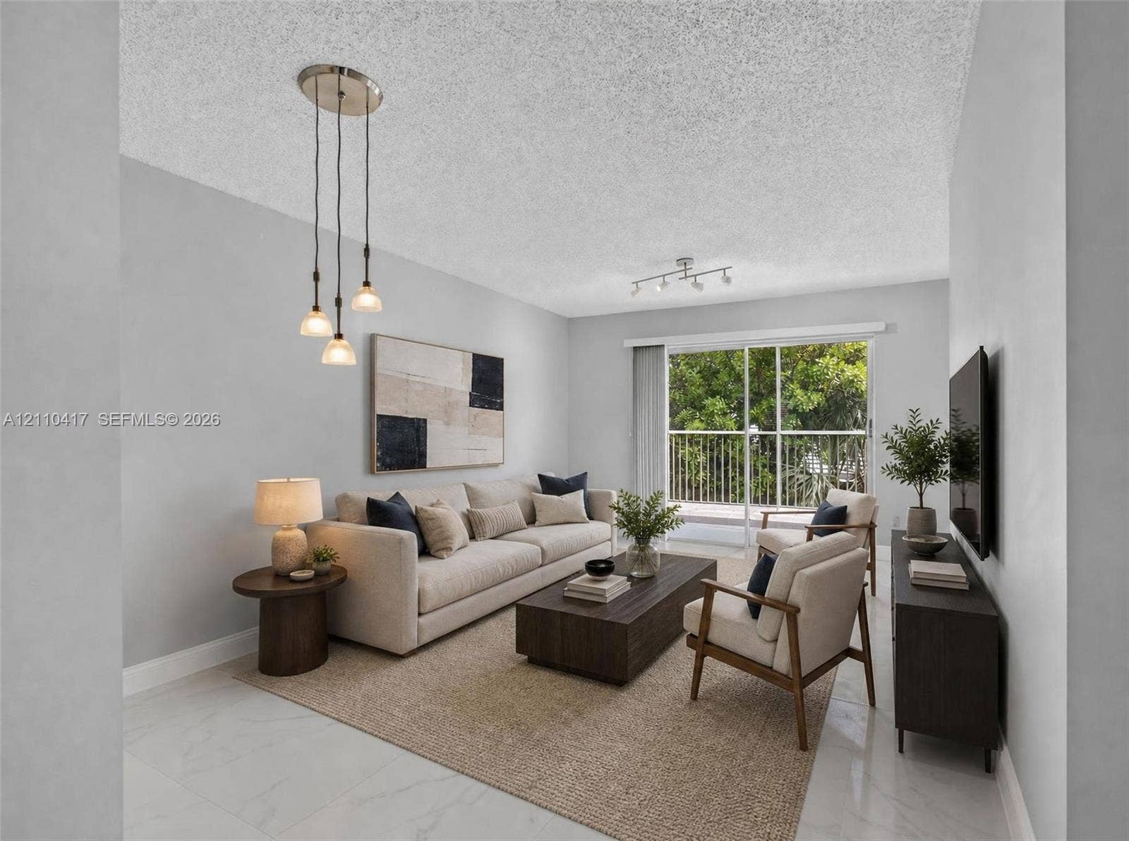 2369 NW 89th Drive, #514, Coral Springs, FL 33065 Living area featuring neutral-toned walls, tile flooring, a multi-light pendant fixture, a secondary track lighting fixture, and glass sliding doors providing external access to a railed balcony