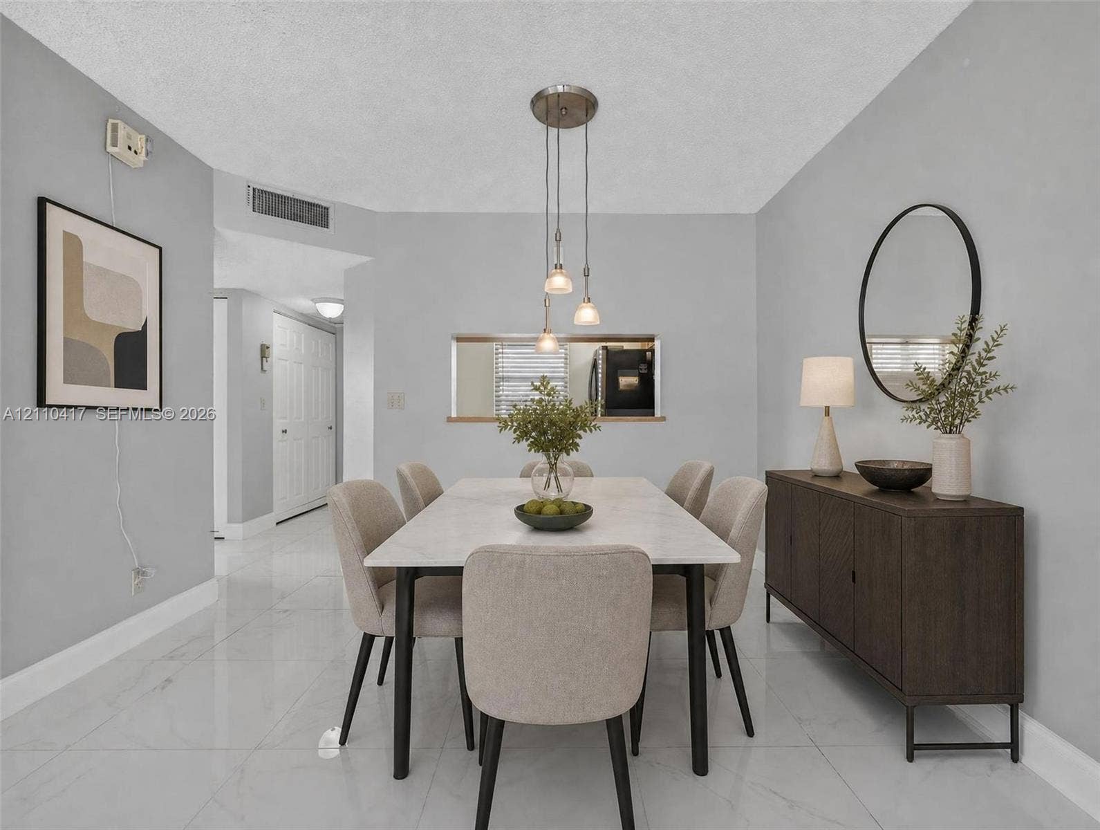 2369 NW 89th Drive, #514, Coral Springs, FL 33065 Dining area featuring neutral wall paint, polished tile flooring, a multi-pendant light fixture, and an interior pass-through window