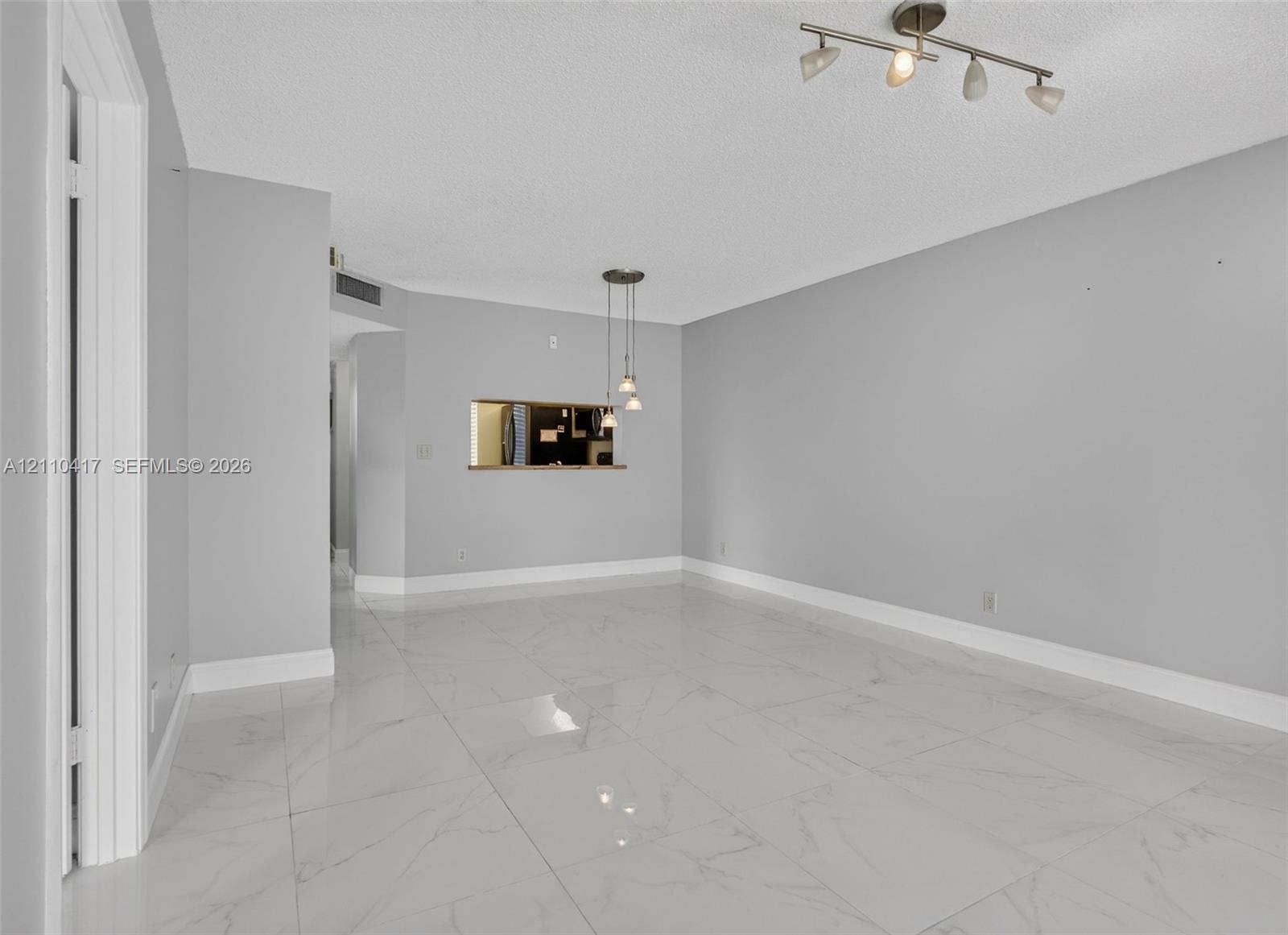 2369 NW 89th Drive, #514, Coral Springs, FL 33065 Large-format tile flooring, recessed pass-through window, three-light pendant fixture, and multi-directional track lighting