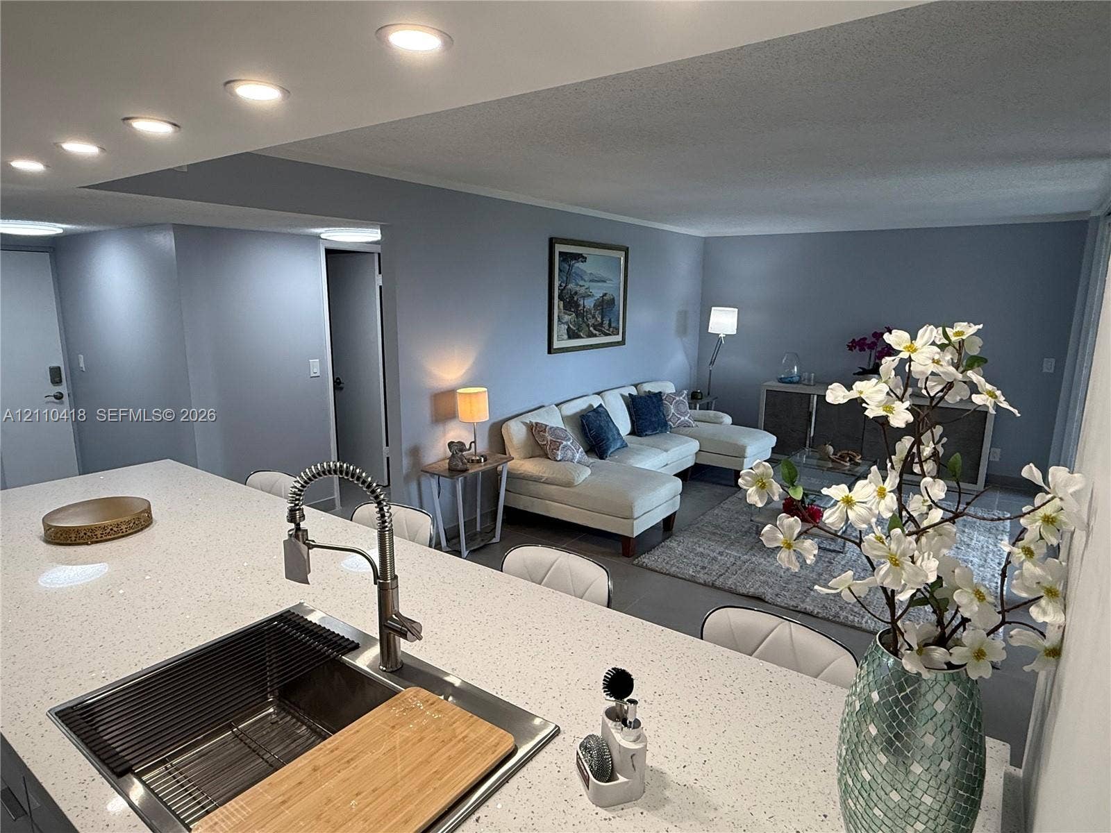 950 Egret Circle, #5409, Delray Beach, Delray Beach, FL 33444 Kitchen featuring a quartz countertop island, undermount stainless steel sink, and high-arc pull-down faucet, recessed ceiling lighting, and solid-finish walls