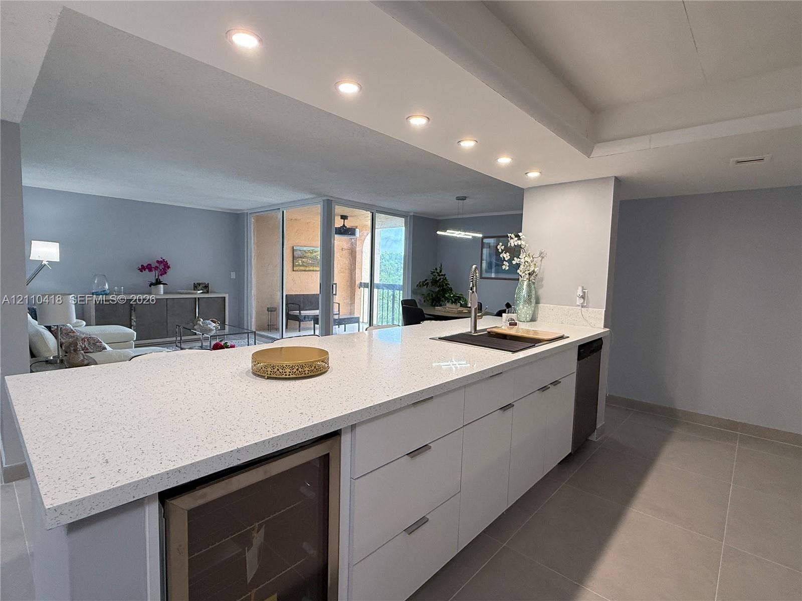 950 Egret Circle, #5409, Delray Beach, Delray Beach, FL 33444 Kitchen island featuring a stone-composite countertop, white flat-panel cabinetry, a built-in wine refrigerator, and recessed lighting