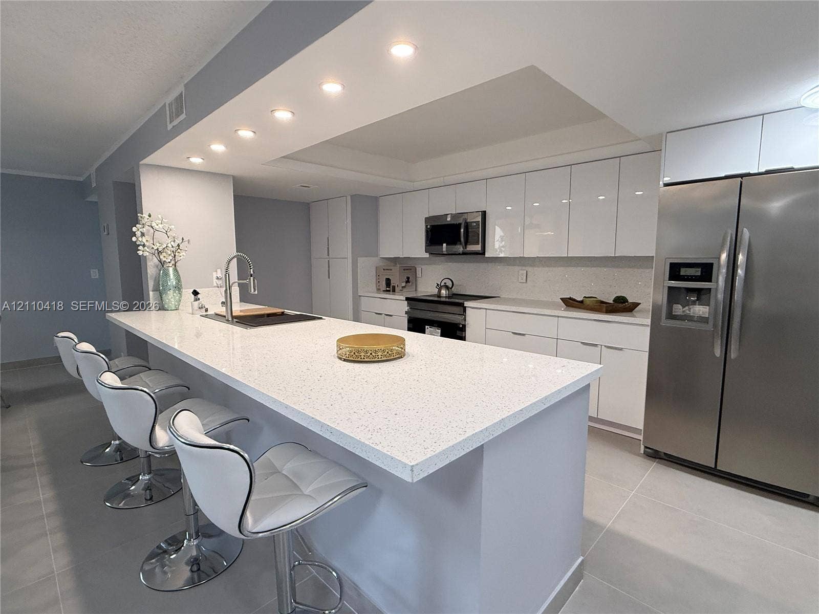 950 Egret Circle, #5409, Delray Beach, Delray Beach, FL 33444 Kitchen featuring white high-gloss cabinetry, stone-finish countertops, stainless steel appliances, recessed ceiling lighting, and large-format tile flooring