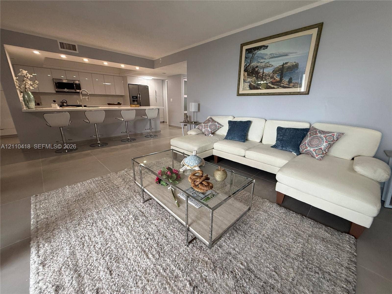 950 Egret Circle, #5409, Delray Beach, Delray Beach, FL 33444 Open-concept kitchen featuring high-gloss cabinetry, stone countertops, and integrated recessed lighting, complemented by large-format tile flooring
