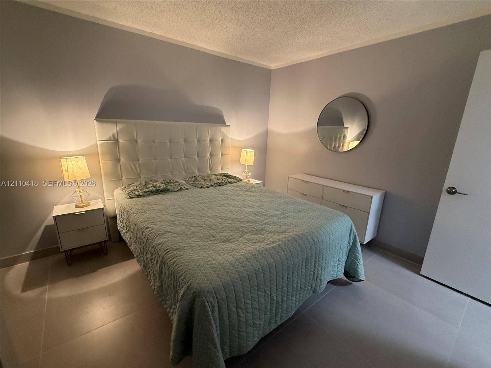 950 Egret Circle, #5409, Delray Beach, Delray Beach, FL 33444 Neutral-toned wall finish, large-format tile flooring, and a circular wall-mounted mirror