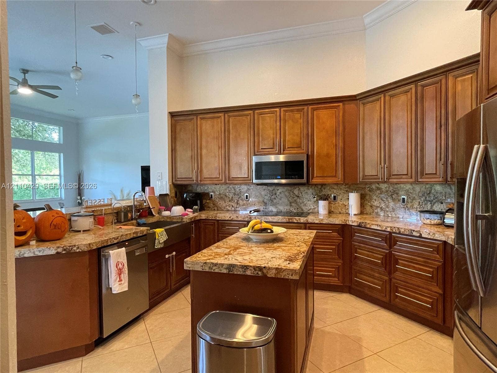 15001 SW 33rd Street, Davie, Davie, FL 33331 Kitchen featuring raised-panel wood cabinetry, natural stone countertops, a center island, tile flooring, and stainless steel appliances