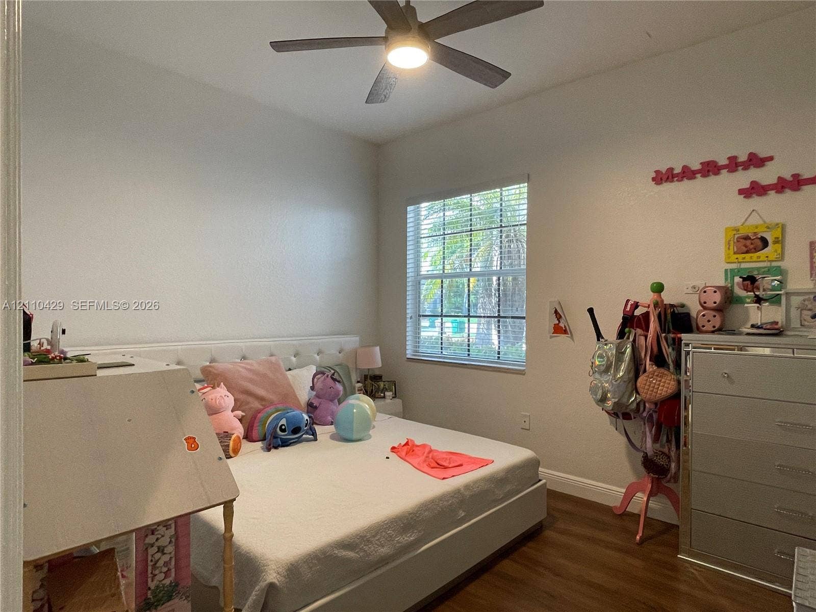 15001 SW 33rd Street, Davie, Davie, FL 33331 Room featuring wood-finish flooring, a multi-blade ceiling fan with integrated lighting, and a window with a grid pattern