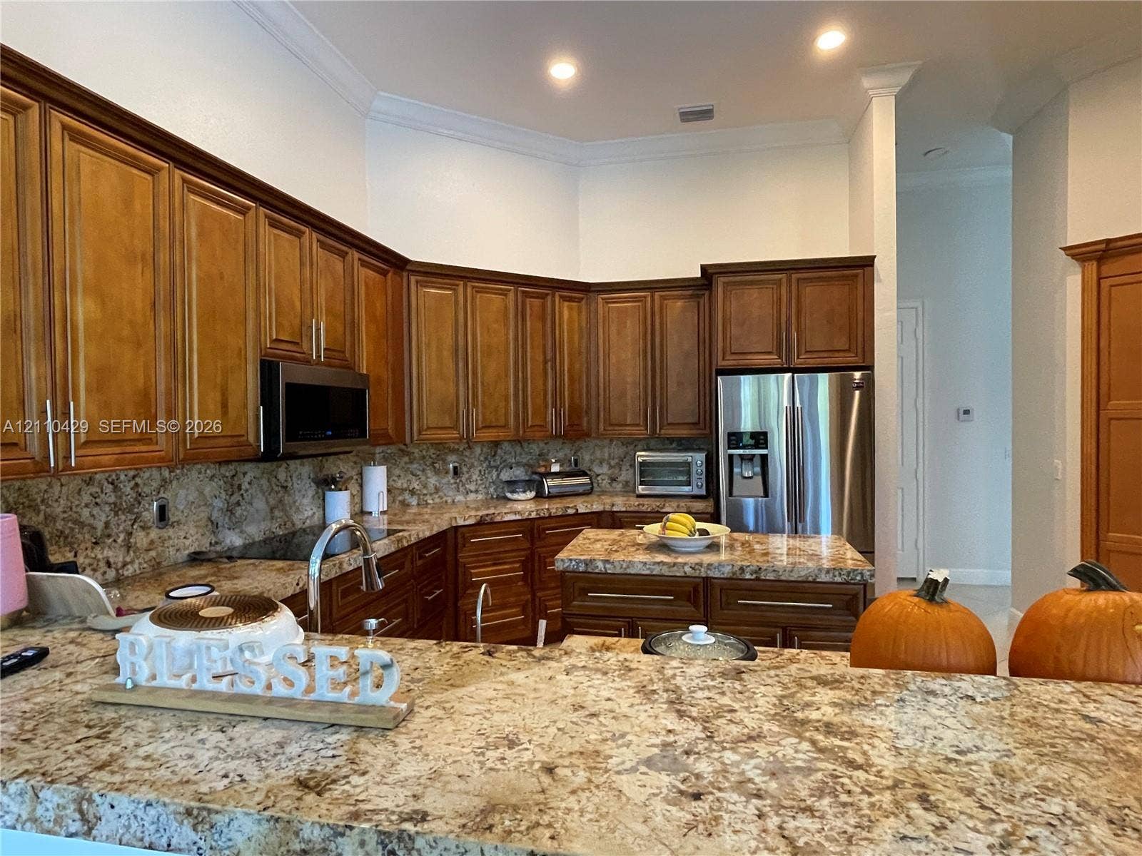 15001 SW 33rd Street, Davie, Davie, FL 33331 Kitchen featuring stained wood cabinetry, stone countertops, a central island, and stainless steel appliances