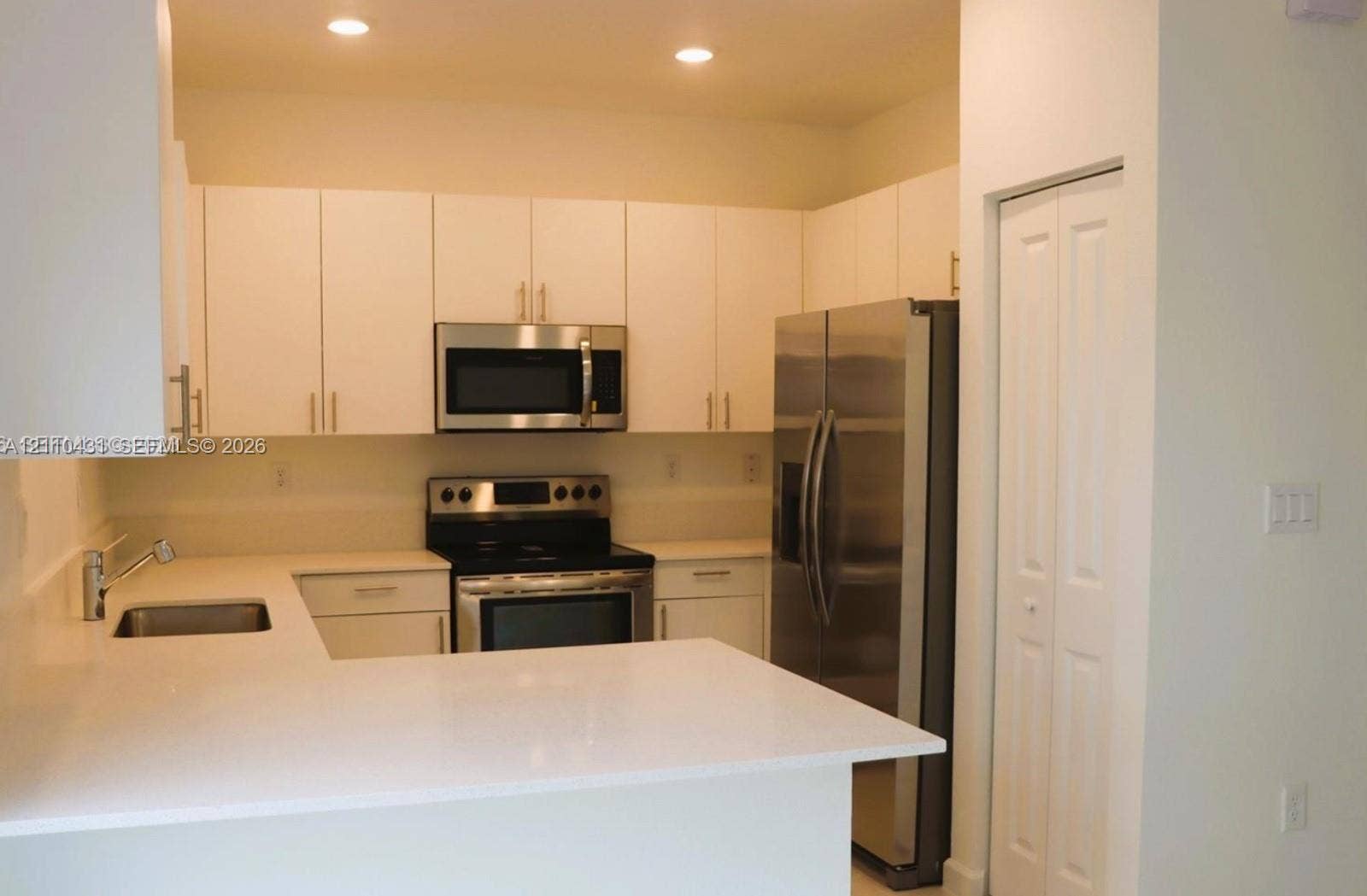23452 SW 129th Avenue, Homestead, FL 33032 Kitchen featuring white cabinetry, solid-surface countertops, recessed lighting, and stainless steel appliances