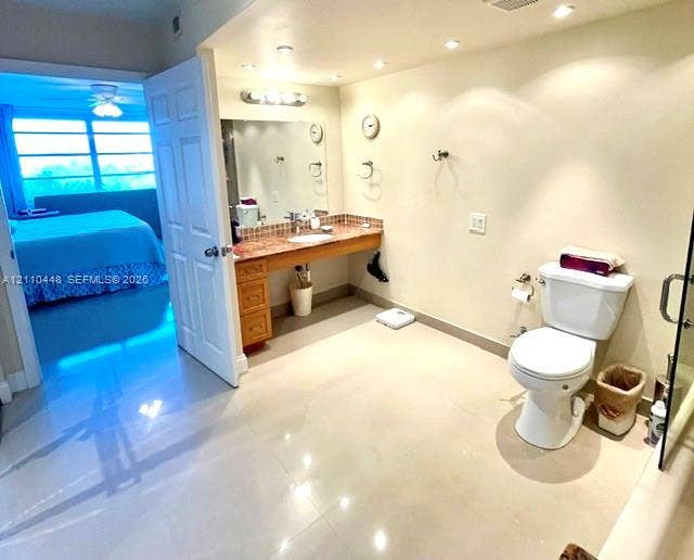 2780 NE 183rd Street, #517, Aventura, FL 33160 Bathroom featuring a natural stone-topped vanity with built-in cabinetry, polished tile flooring, recessed ceiling lighting, and a wall-to-wall mirror