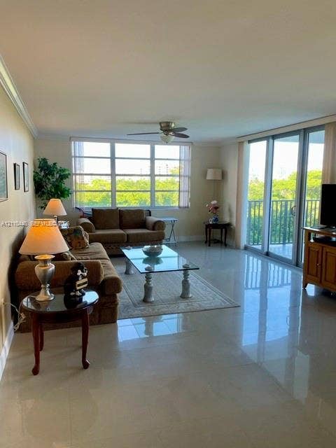 2780 NE 183rd Street, #517, Aventura, FL 33160 Large-format tile flooring, oversized picture windows, sliding glass balcony doors, and a ceiling-mounted fan