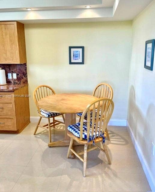 2780 NE 183rd Street, #517, Aventura, FL 33160 Natural wood cabinetry, stone countertops, large-format tile flooring, and recessed ceiling lighting