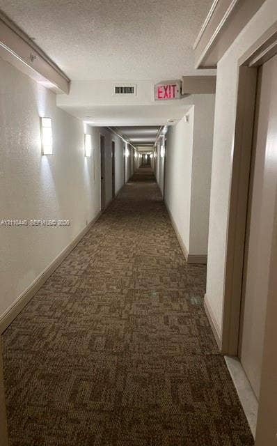 2780 NE 183rd Street, #517, Aventura, FL 33160 Hallway featuring wall-mounted light fixtures and patterned carpeting