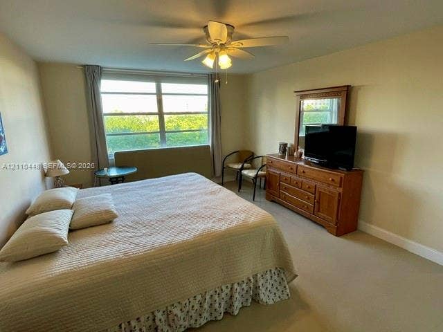 2780 NE 183rd Street, #517, Aventura, FL 33160 Large multi-pane window with natural lighting, neutral wall-to-wall carpeting, and a central ceiling fan with multi-light fixture