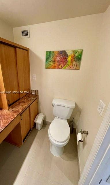 2780 NE 183rd Street, #517, Aventura, FL 33160 Built-in wood cabinetry with stone-finish countertop, dual-door storage, and a white porcelain toilet