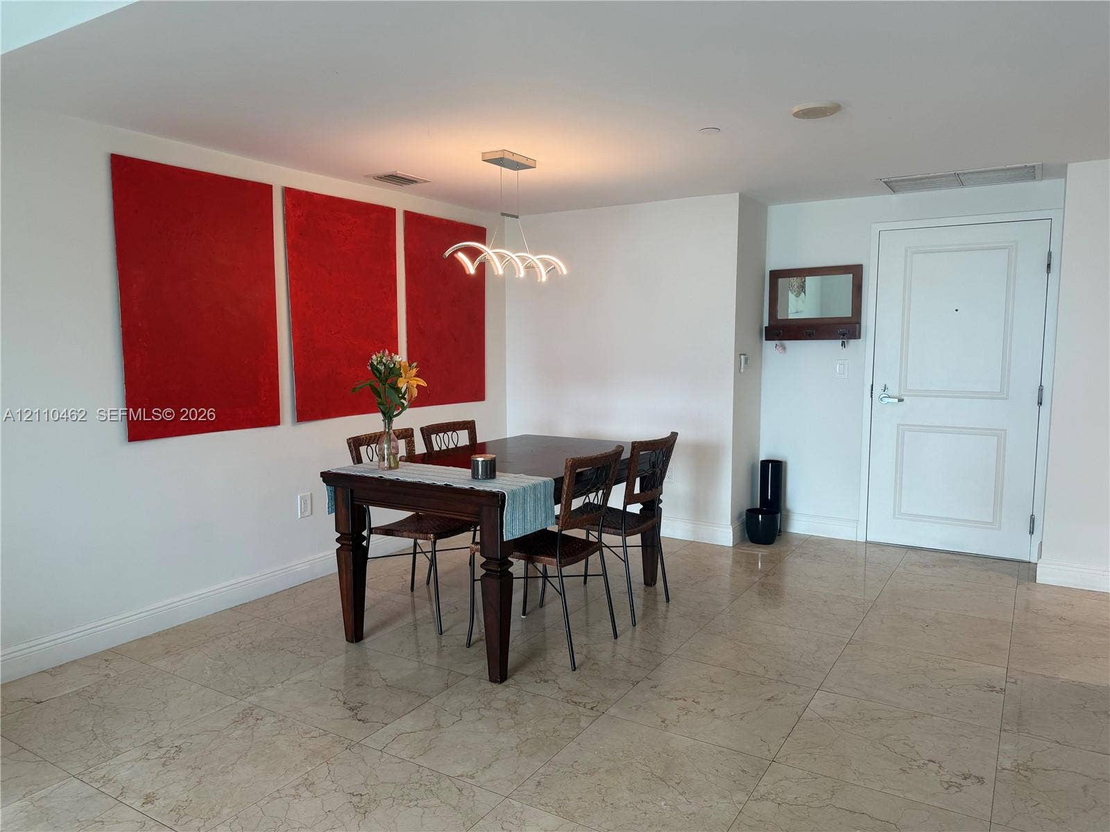 Polished stone tile flooring, contemporary multi-arm pendant lighting, and a solid-core panel door featuring polished chrome hardware