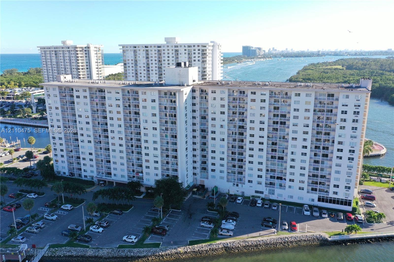 High-rise residential building featuring private balconies, expansive waterfront positioning, and on-site surface parking