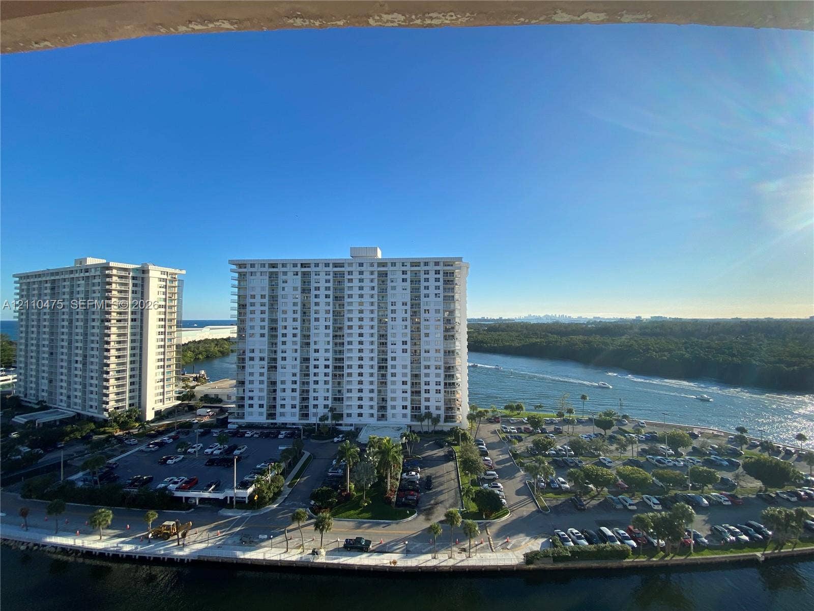 Elevated coastal perspective featuring expansive water frontage, deep-water inlet access, and manicured palm-lined landscaping