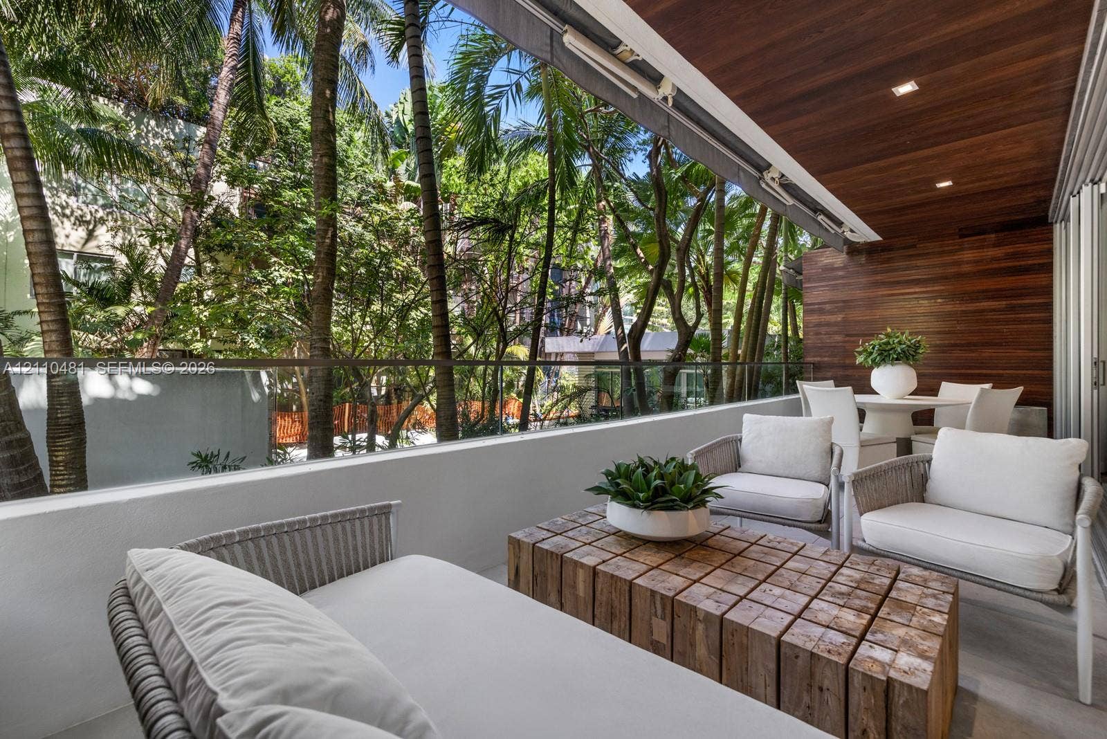 234 Washington Avenue, #D, Miami Beach, FL 33139 Covered balcony featuring wood-plank ceiling and wall cladding, glass pane railing, and recessed lighting