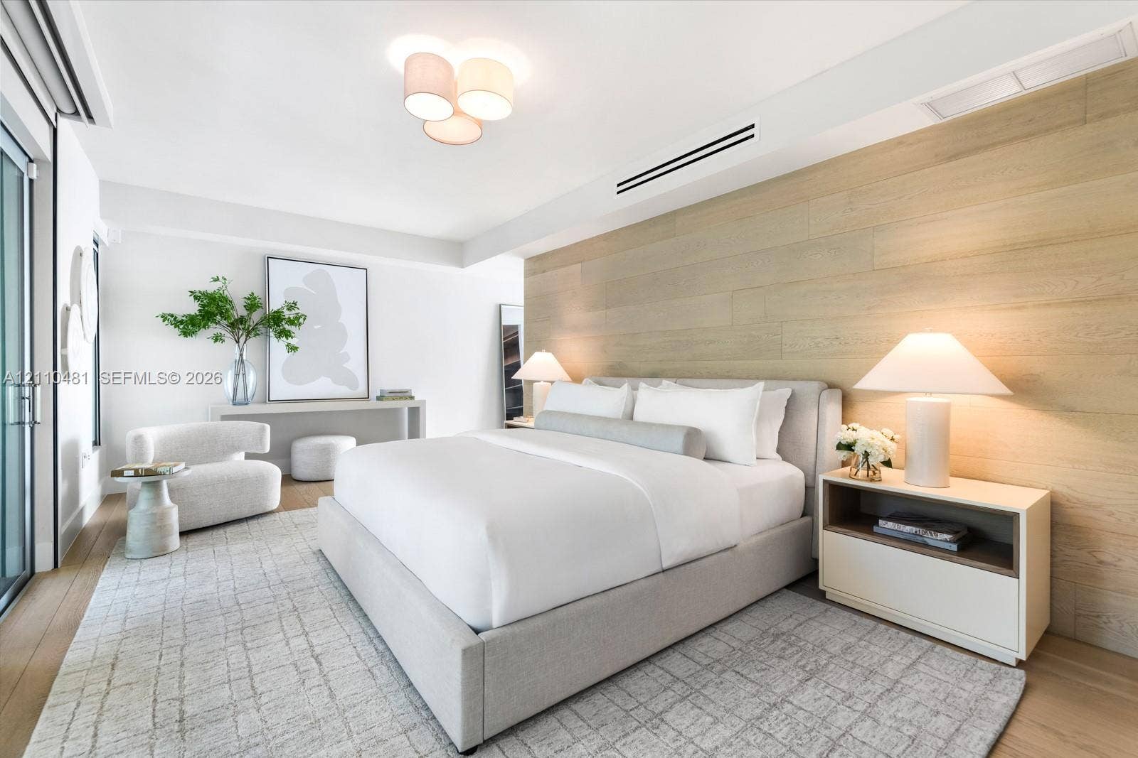 234 Washington Avenue, #D, Miami Beach, FL 33139 Wood-finish wall paneling, light wood-finish flooring, recessed ceiling lighting, multi-bulb flush-mount fixture, and floor-to-ceiling glass door